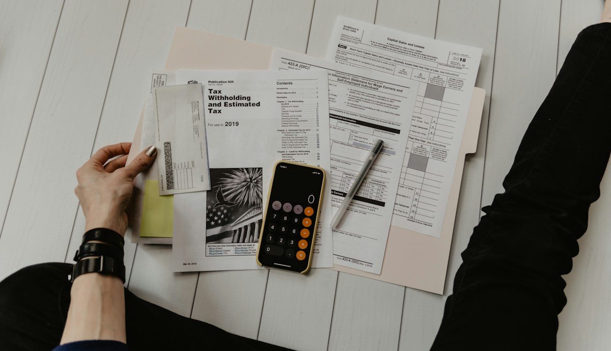 Calculator and financial paperwork used for percentage and budget calculations